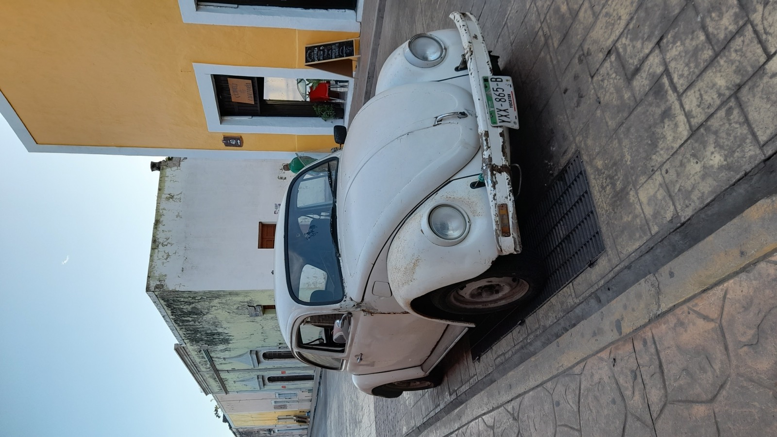 A classic Volkswagen Beetle on a colonial street in Valladolid.