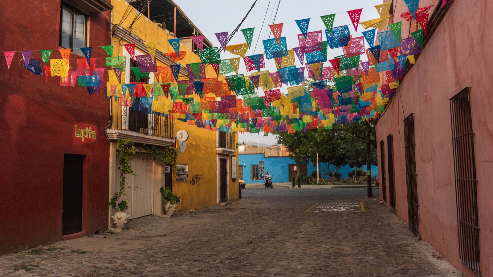 A colourful street decorated with papel picado banners in Oaxaca.