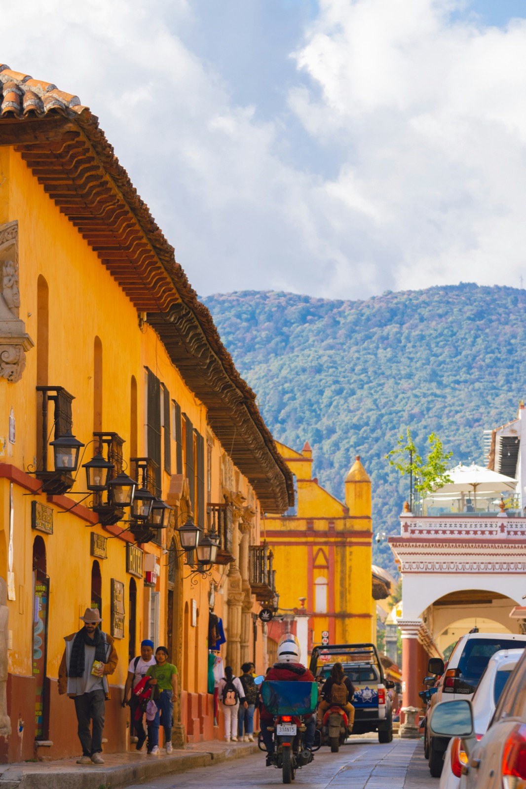 A colonial street in San Cristóbal de las Casas with the surrounding mountains.